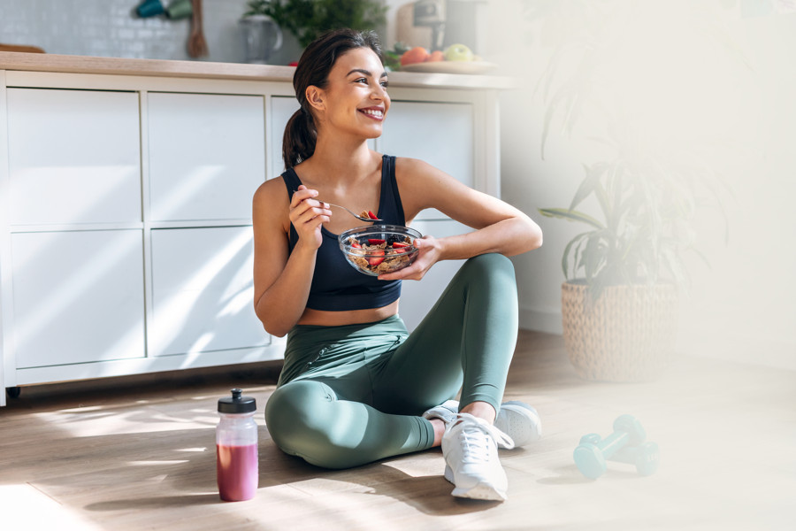 Woman opening a direct-to-home wellness box in her kitchen